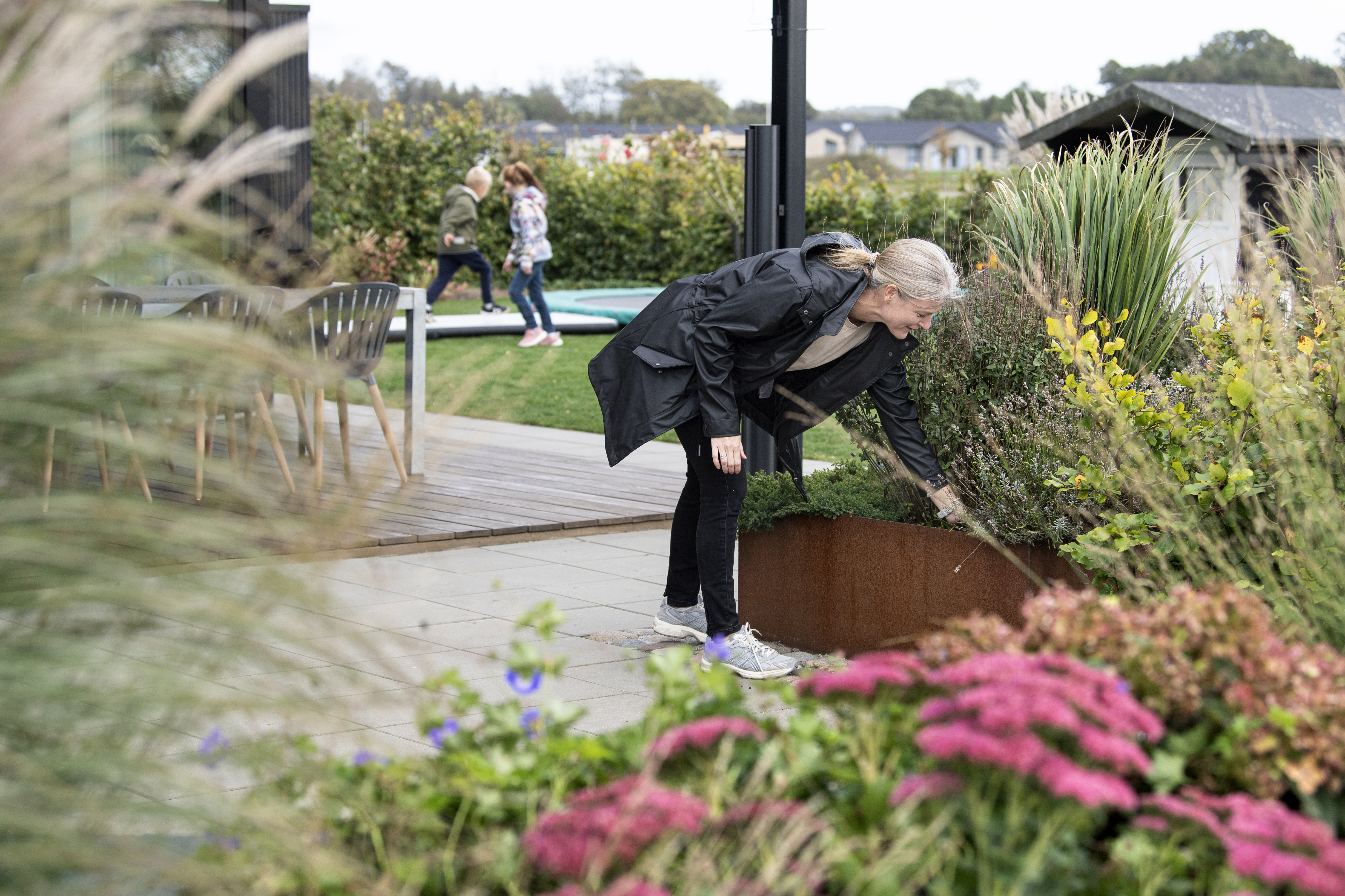 Mor luer bede mens børn leger i haven