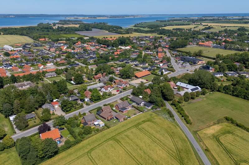 Dronefoto af Glud by på en sommerdag
