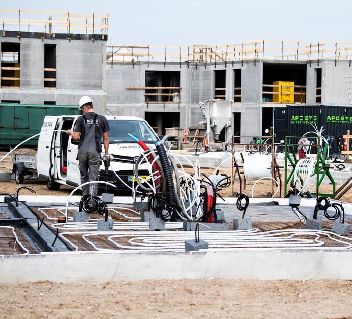 Byggeplads med håndværkere, som er ved at bygge ny erhvervsbygning